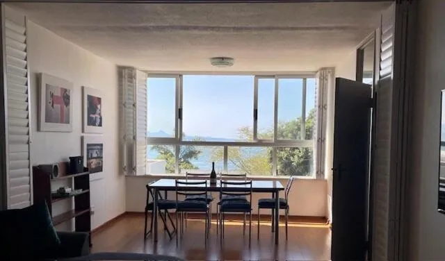 Dining table for six set beneath a window looking straight out to the bay