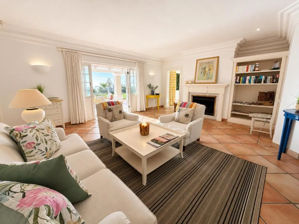 Lounge with a fireplace, built-in bookshelves and armchairs on a striped rug