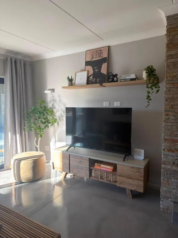 Living area TV unit with floating display shelf and a stone feature pillar