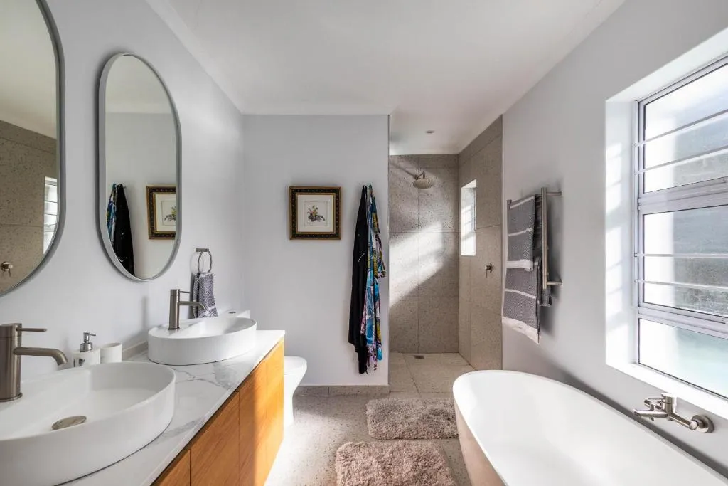 Ensuite bathroom with a double vanity, walk-in shower and a freestanding oval tub