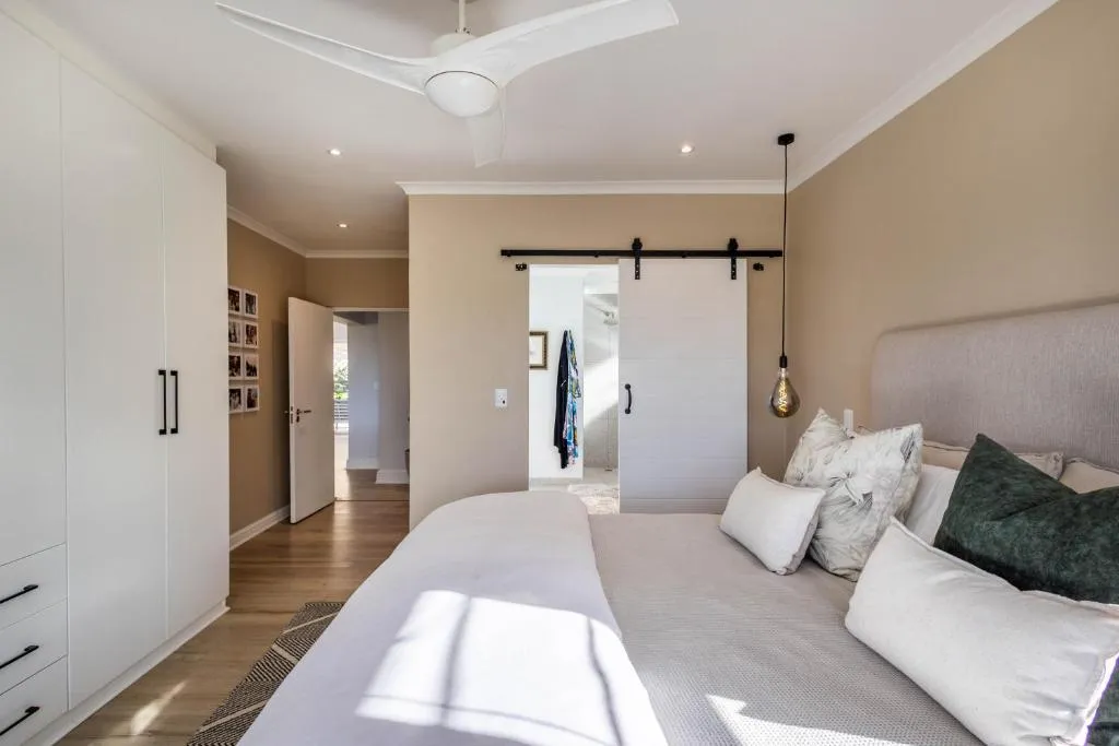 Bedroom with white fitted wardrobes and a sliding barn door opening to the ensuite