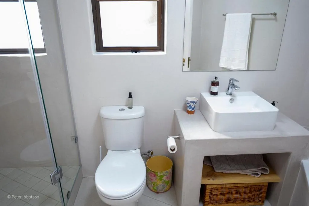 Bathroom with a freestanding vanity, toilet and a glass-enclosed shower
