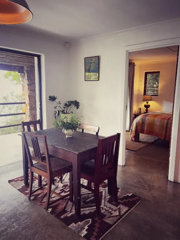 Dining table with a view through to a bedroom and a stone-walled balcony beyond