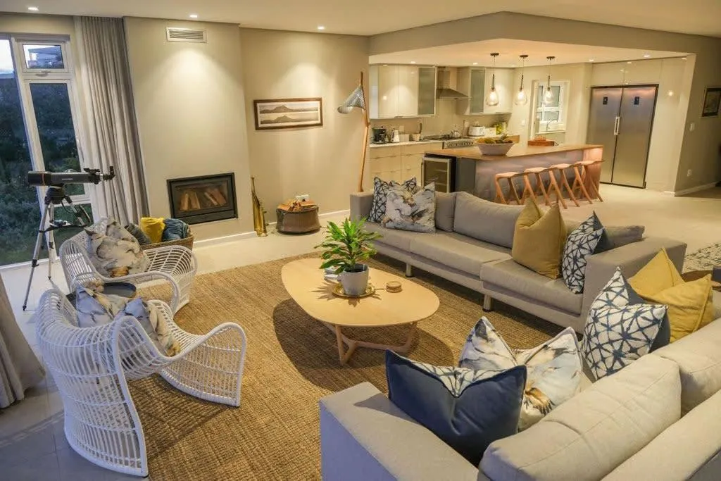 Open-plan living room with a gas fireplace and kitchen with breakfast bar beyond