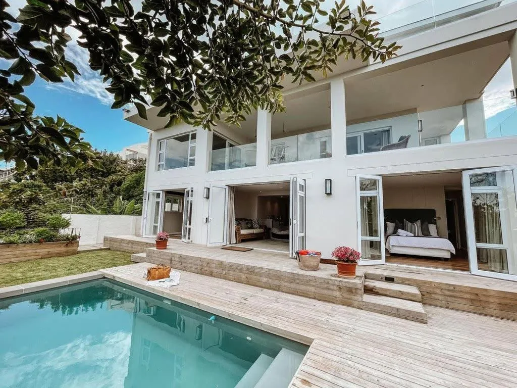 Ground-floor pool deck and garden with French doors opening from the bedrooms