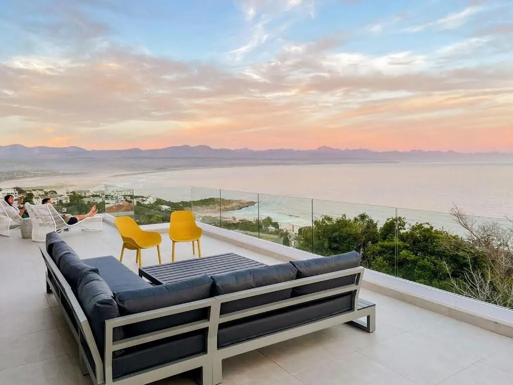 Upper terrace lounge at sunset with uninterrupted views over the coastline and ocean