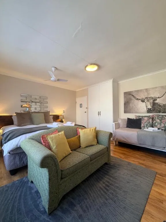 Studio room with double bed, armchair sofa and built-in wardrobe under a longhorn print