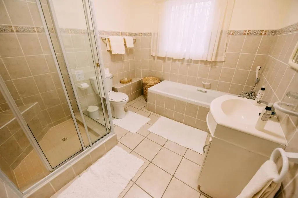 En-suite bathroom with a bathtub, walk-in shower and vanity basin