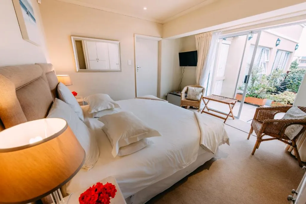 Bedroom opening onto a private courtyard patio with wicker seating