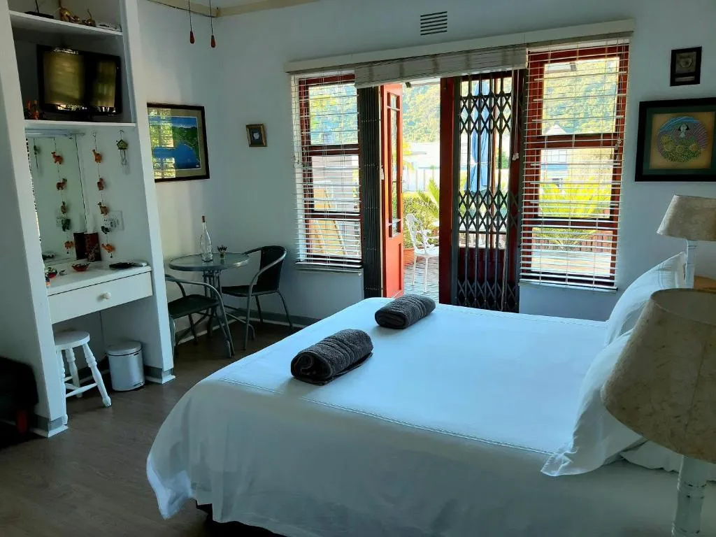 Bedroom with a mountain view through open French doors and a small dressing table