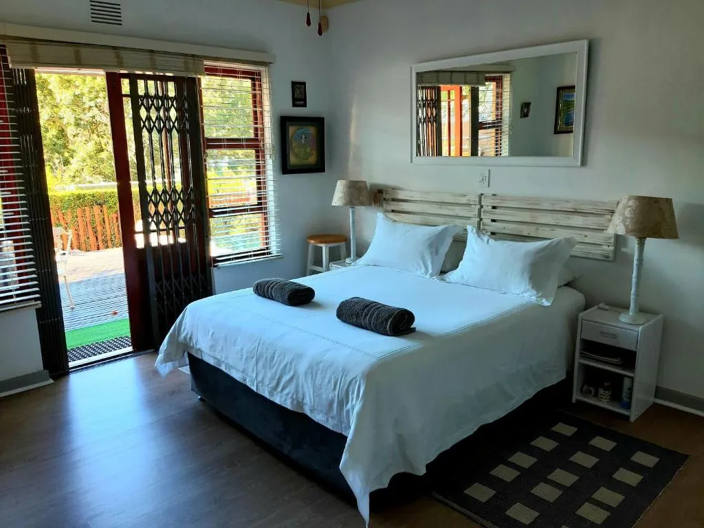 Bedroom with a slatted timber headboard and a security-gated sliding door onto a garden deck