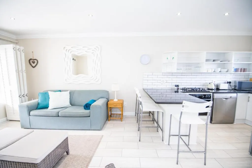Kitchen with subway-tiled splashback, gas hob, dishwasher and breakfast bar seating