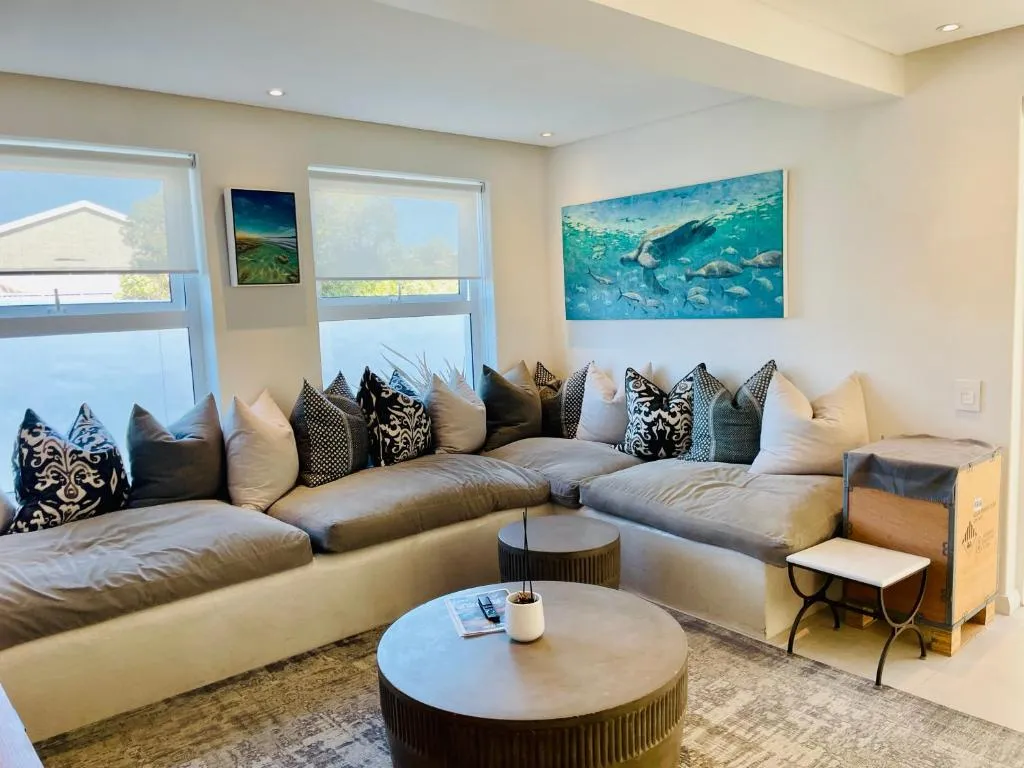 Living room with a low built-in daybed sofa and ocean-themed artwork