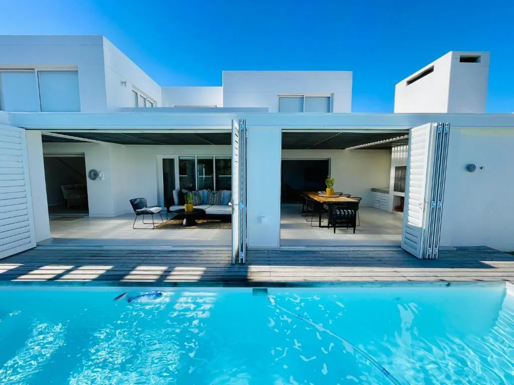 Folding glass doors open the lounge and dining room directly onto the pool deck
