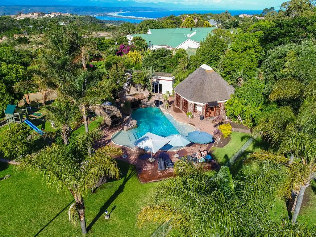Aerial view of the resort grounds showing the pool, thatched lapa, lawns and a children's play area