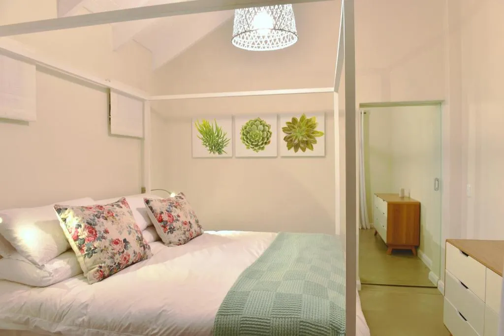 Canopy bed with botanical prints and a sliding door to a dressing area