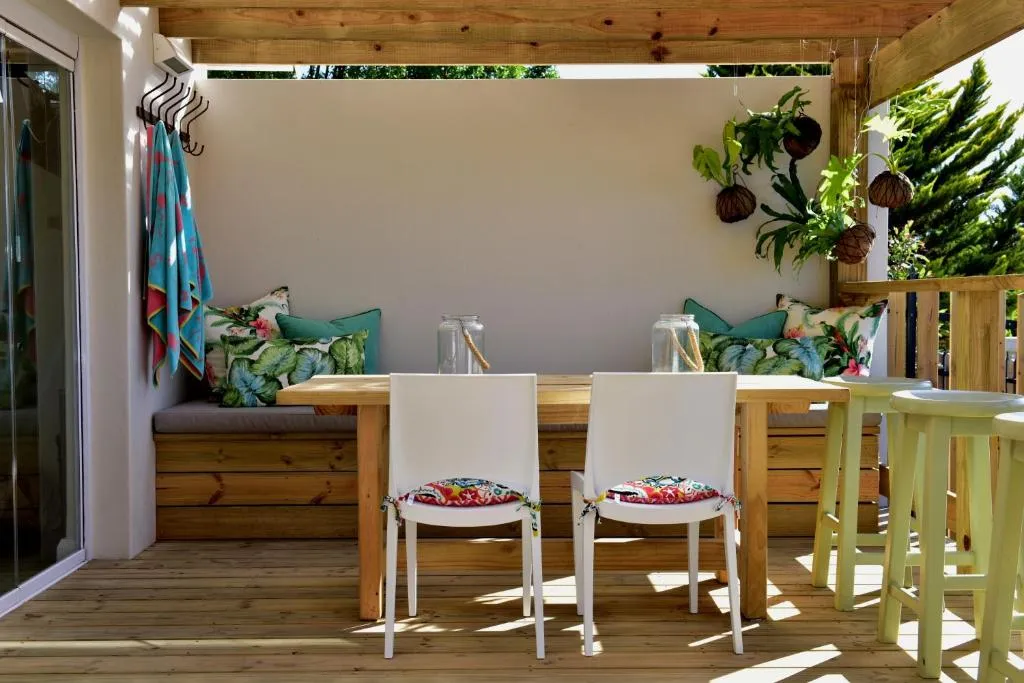 Covered timber deck with built-in bench seating and a dining table for two