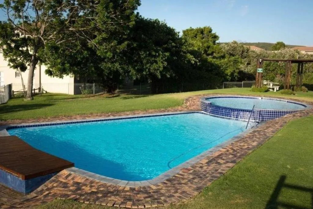 Communal garden pool with a round plunge-pool feature and pergola seating