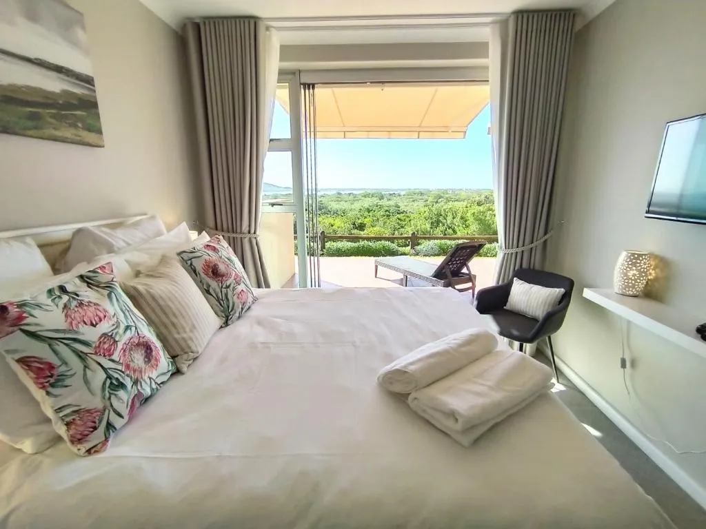 Bedroom with floral cushions and glass doors open to the patio and lagoon view