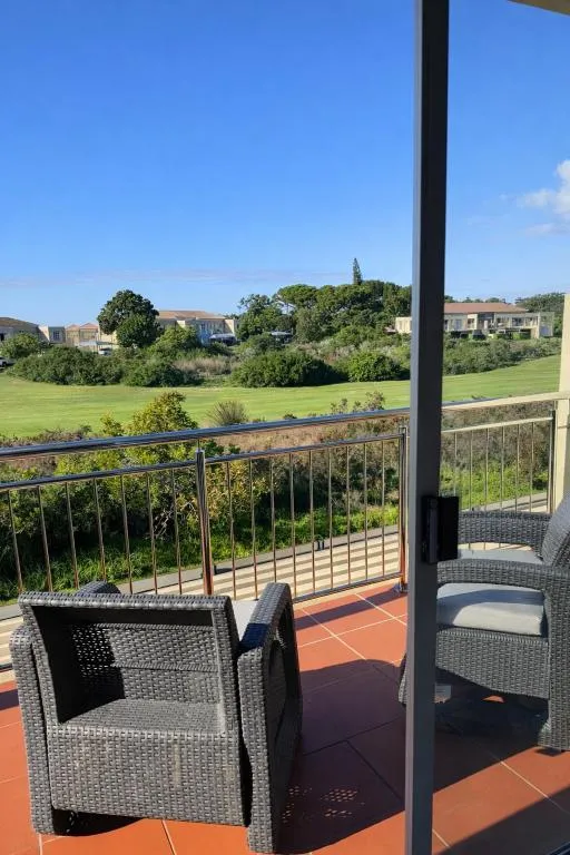 Balcony seating overlooking the golf fairway toward the estate and hills