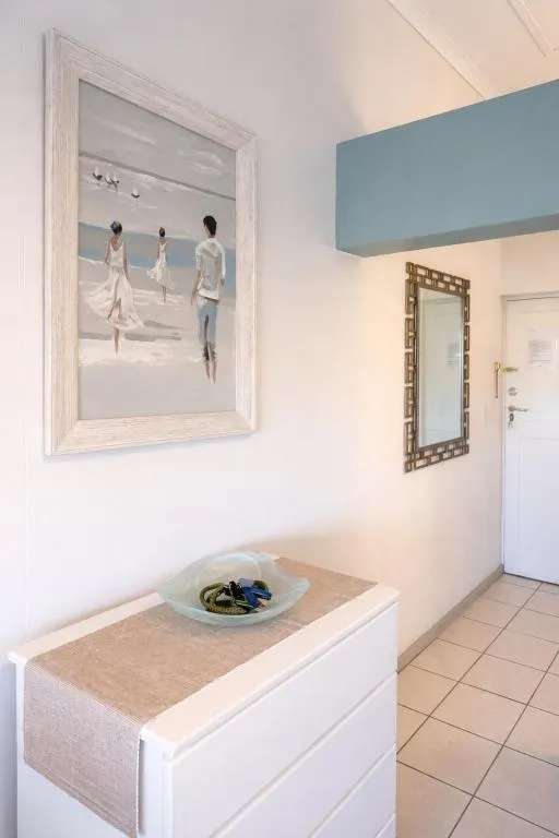 Entrance hallway with framed beach artwork and a console table