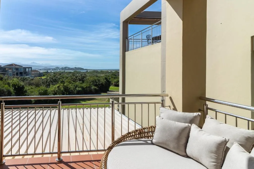 Private terrace with a built-in cushioned bench overlooking the golf fairway, lagoon and hills