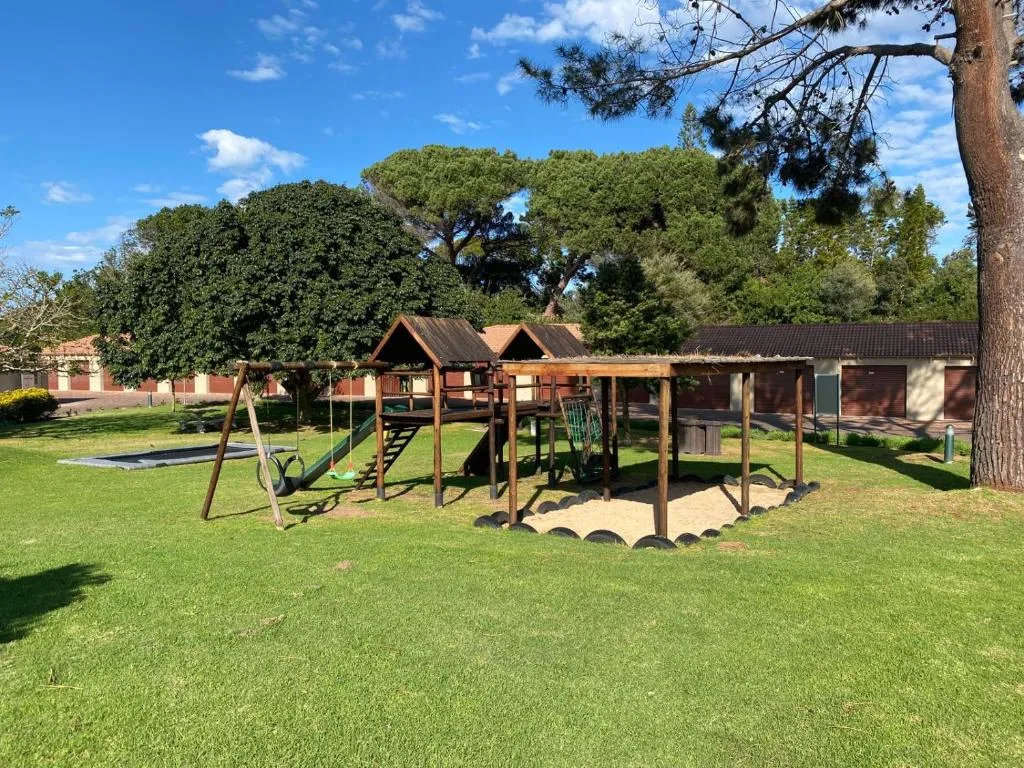 Estate playground with swings, slide, trampoline and jungle gym on the communal lawn