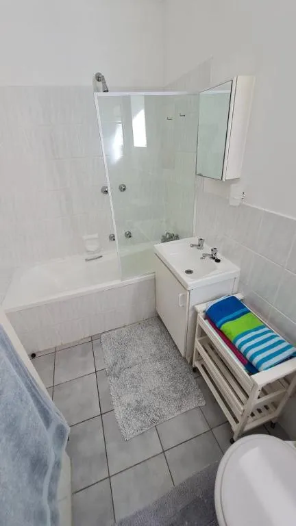 Bathroom with a corner bath, glass shower screen and pedestal-style vanity basin