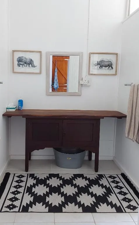 Rustic bathroom vanity with rhino prints and a mirror over a wooden washstand