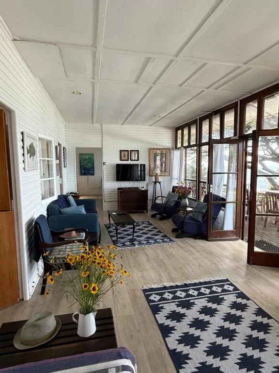 Living room opening through French doors onto a deck with sea views