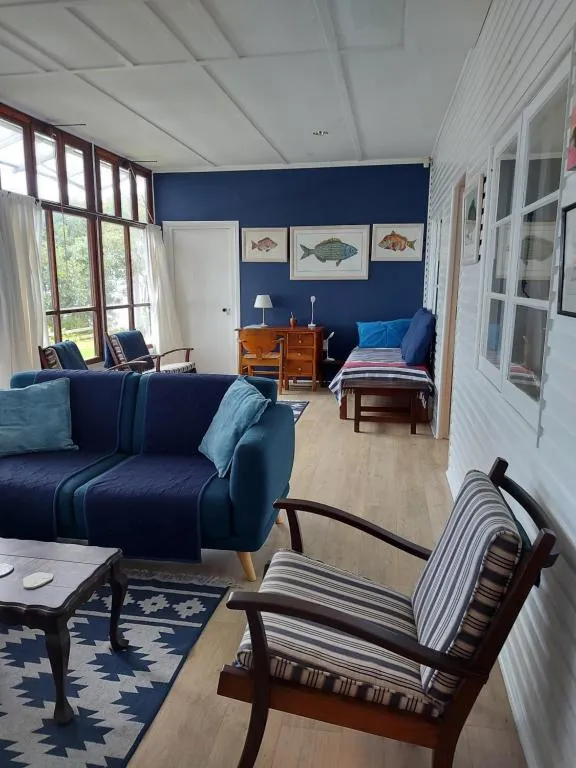 Living room with a navy accent wall, framed fish prints and a blue sofa