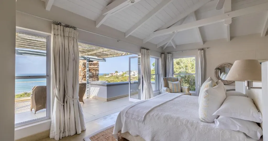 Bedroom with folding doors opening onto a private balcony over the sea