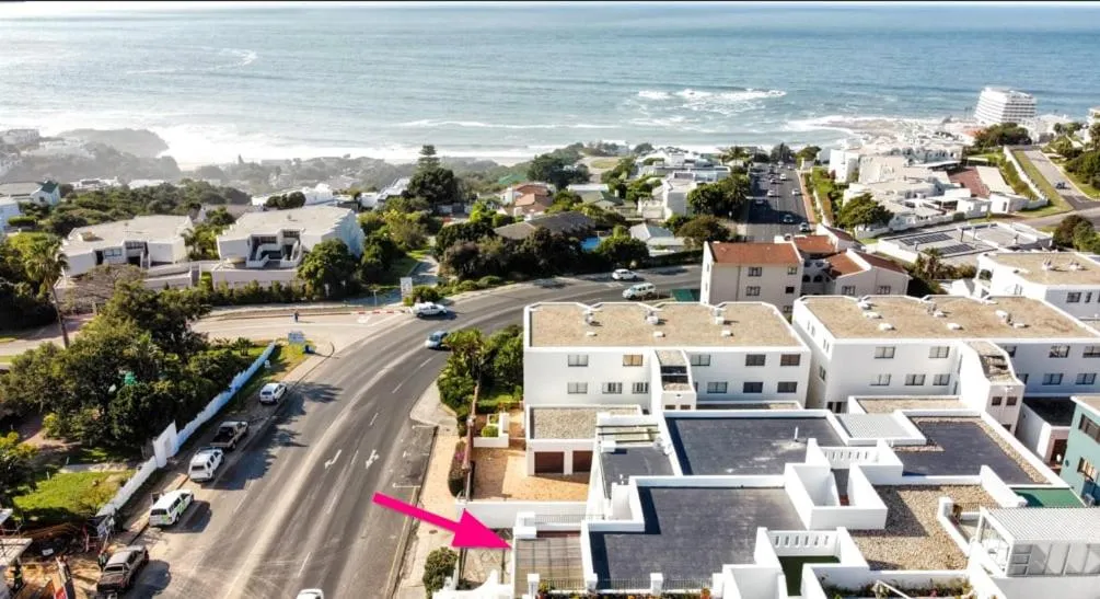 Aerial view of the building's beachfront position marked above the road and parking area