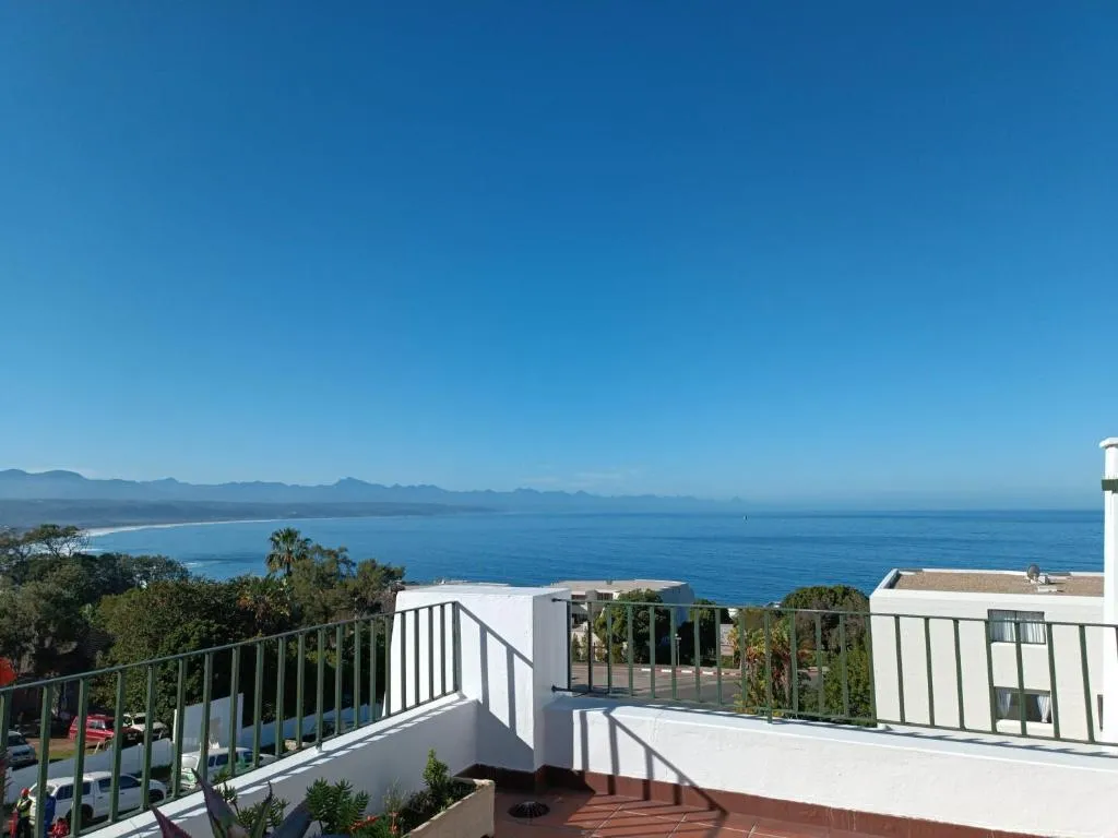 Panoramic balcony view over the coastline, beach and mountains from the upper floor