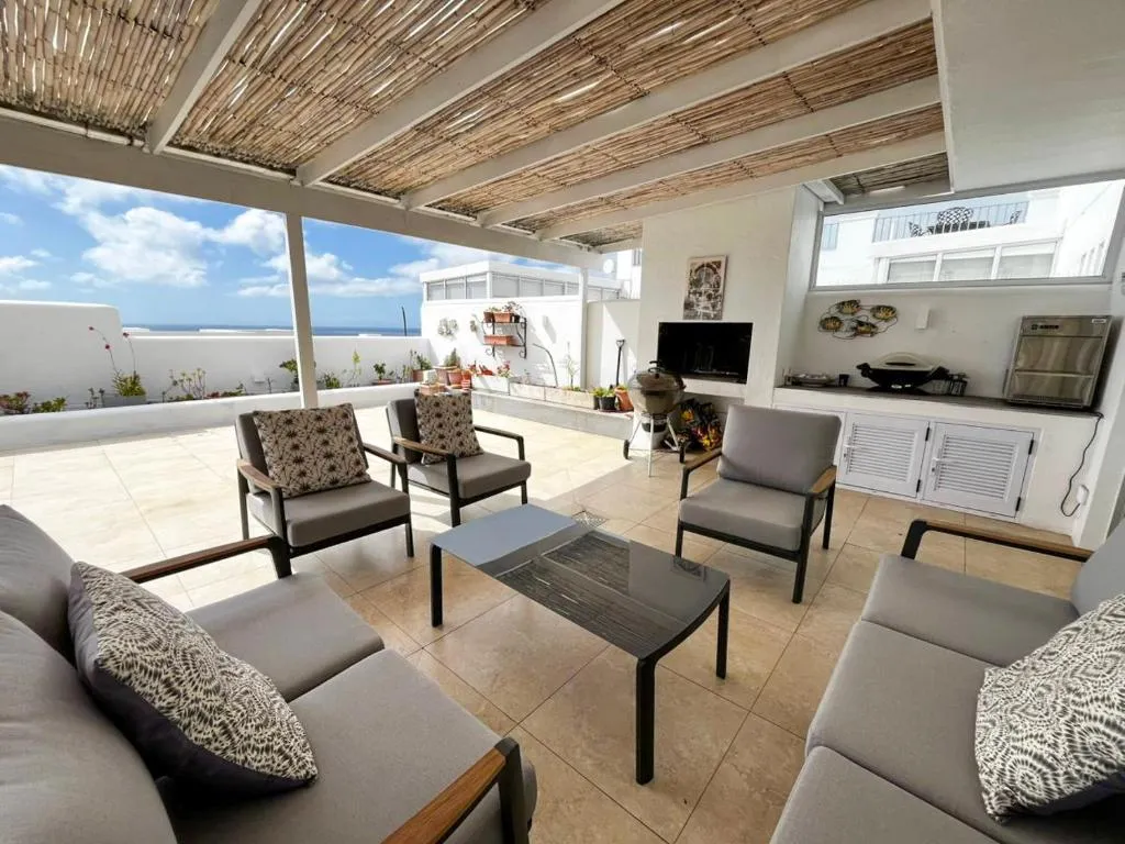 Covered outdoor lounge with built-in braai, fireplace and sea view