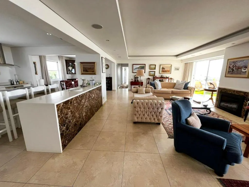 Open-plan living, dining and kitchen area with a marble-clad fireplace