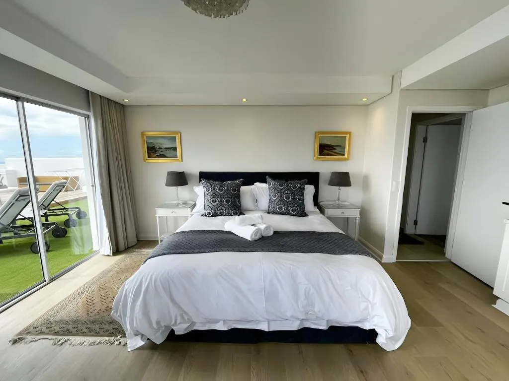 Main bedroom with king bed and sliding doors onto the terrace overlooking the sea