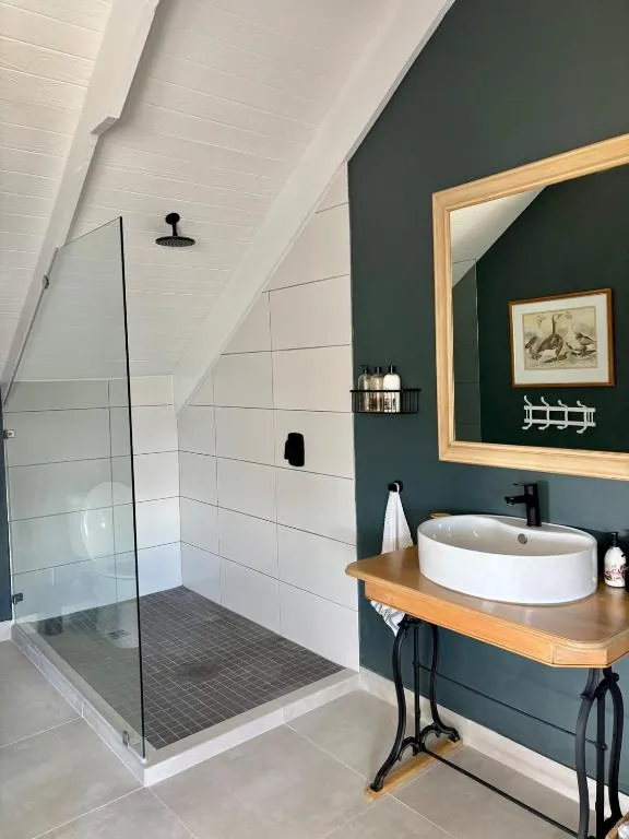 En-suite bathroom with a glass walk-in shower and vessel sink against a dark green wall