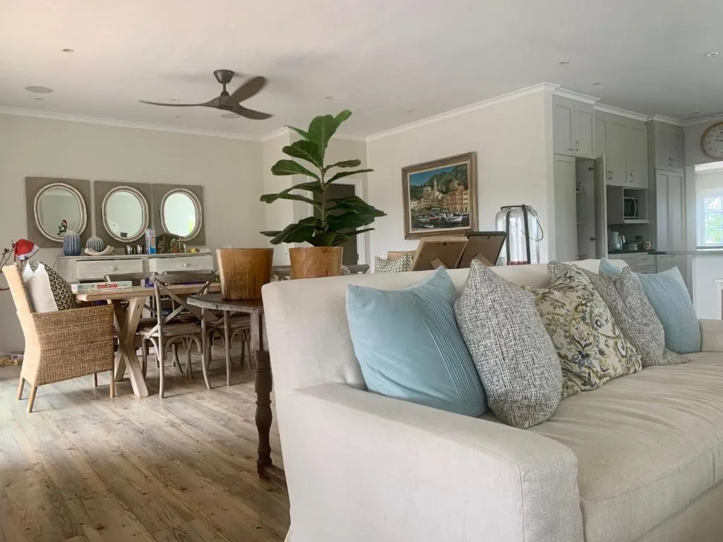 Living area with a large sofa, dining table and open-plan kitchen with fitted cabinetry