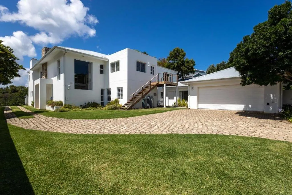 Two-storey modern house exterior with a balcony, double garage and paved driveway