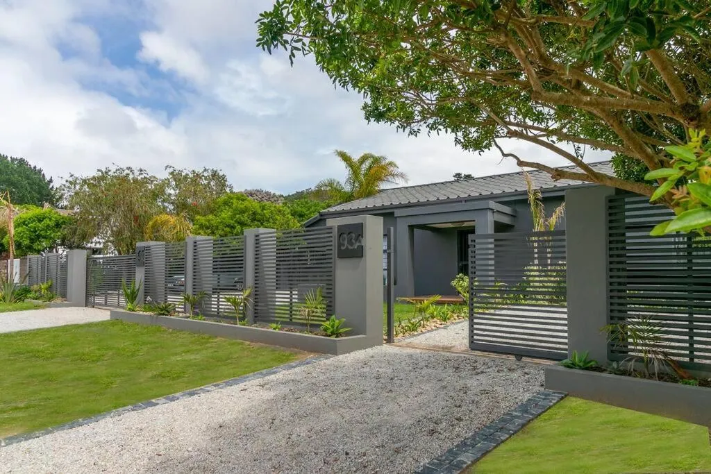 Slatted grey gate and boundary wall along the driveway leading to the house entrance