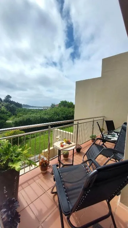 Furnished balcony with wine and snacks on a side table overlooking the lagoon