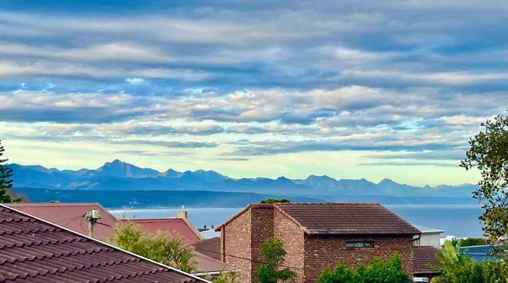 View over neighbouring rooftops to the sea and the Outeniqua mountains in the distance