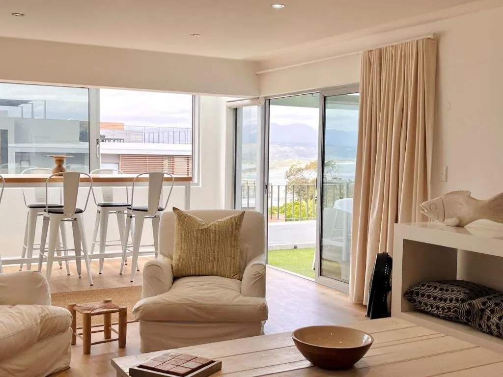 Living room with a bar-height kitchen counter and sliding doors onto a lagoon-view balcony