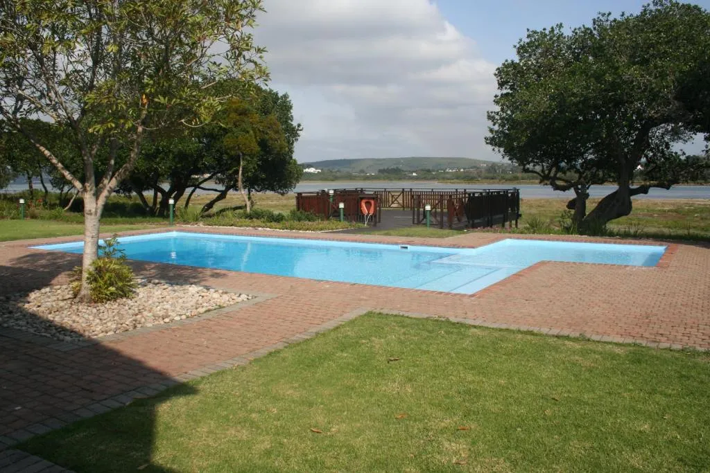 Shared estate swimming pool surrounded by lawn and trees, overlooking the Keurbooms river