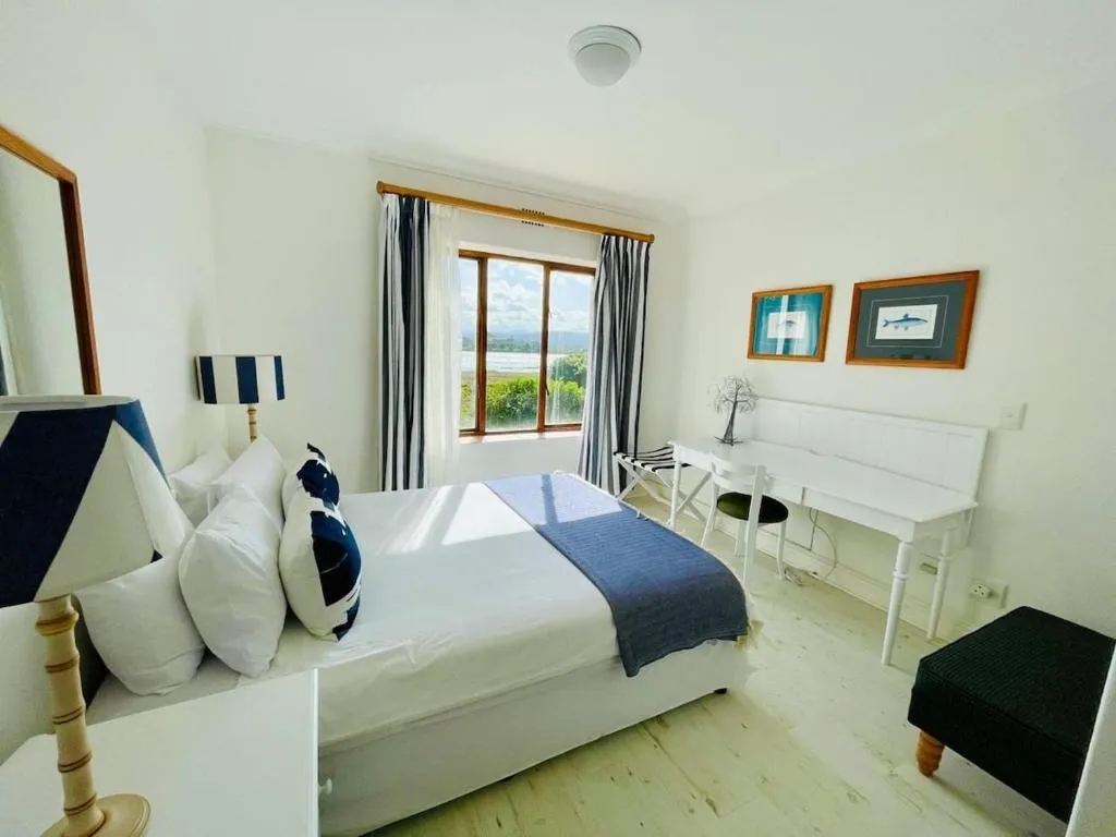 Nautical-themed bedroom with navy accents, a window bench and fish-print artwork