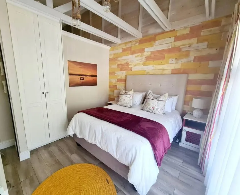 Bedroom with a king bed, timber accent wall and vaulted raftered ceiling