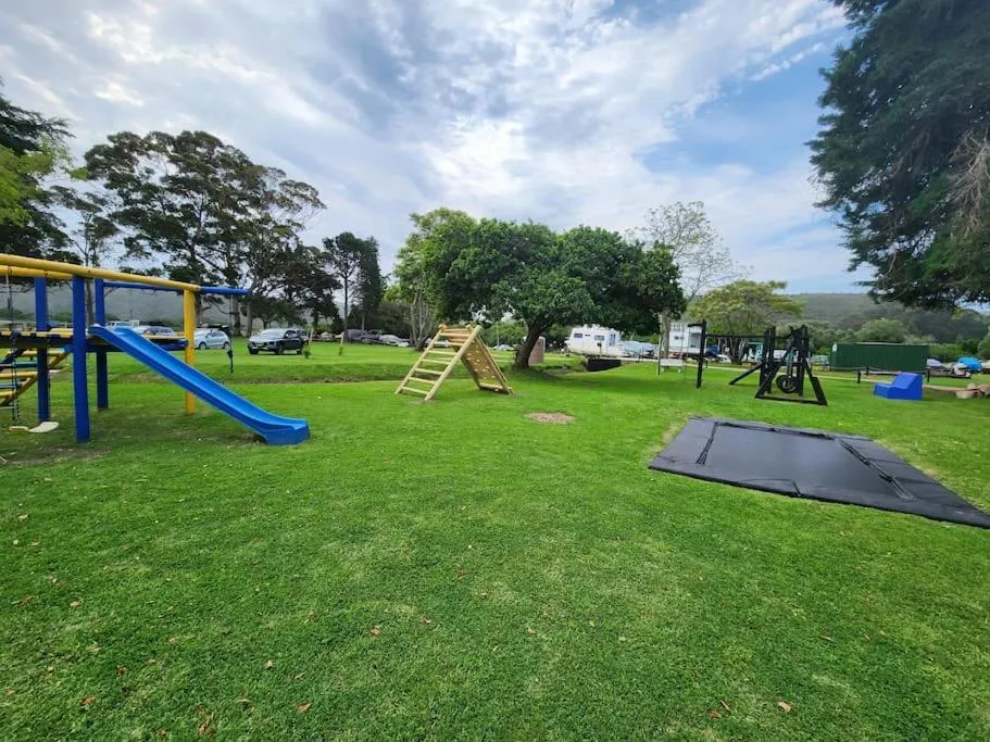 Communal playground with a slide, swings and trampoline on the complex lawn