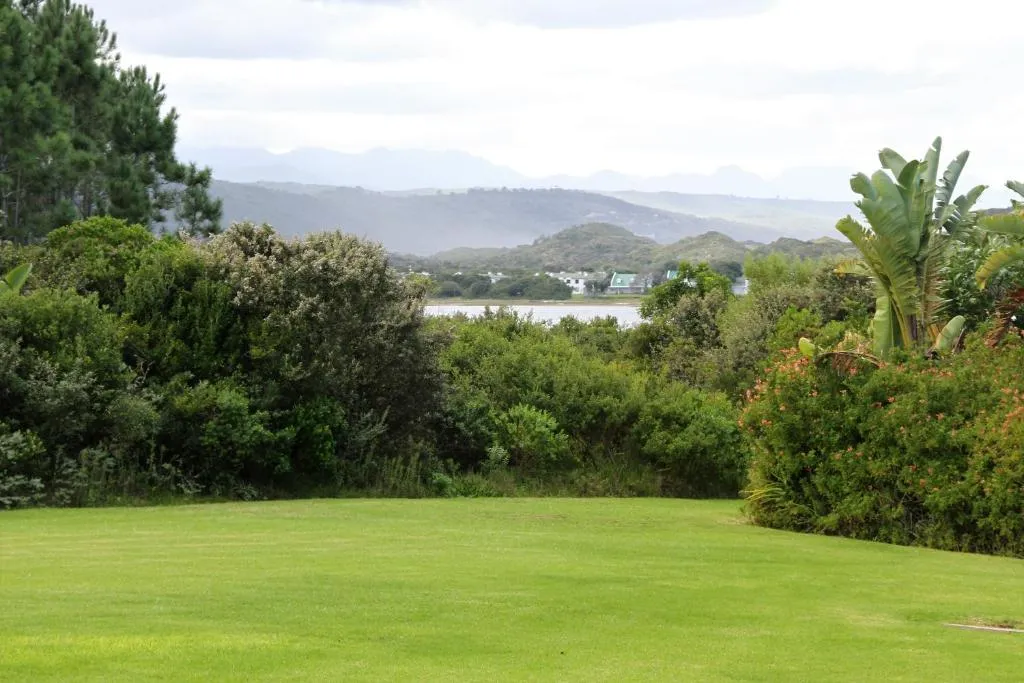 Lawn view over indigenous bush to a lagoon and mountains from Goose Valley Golf Estate