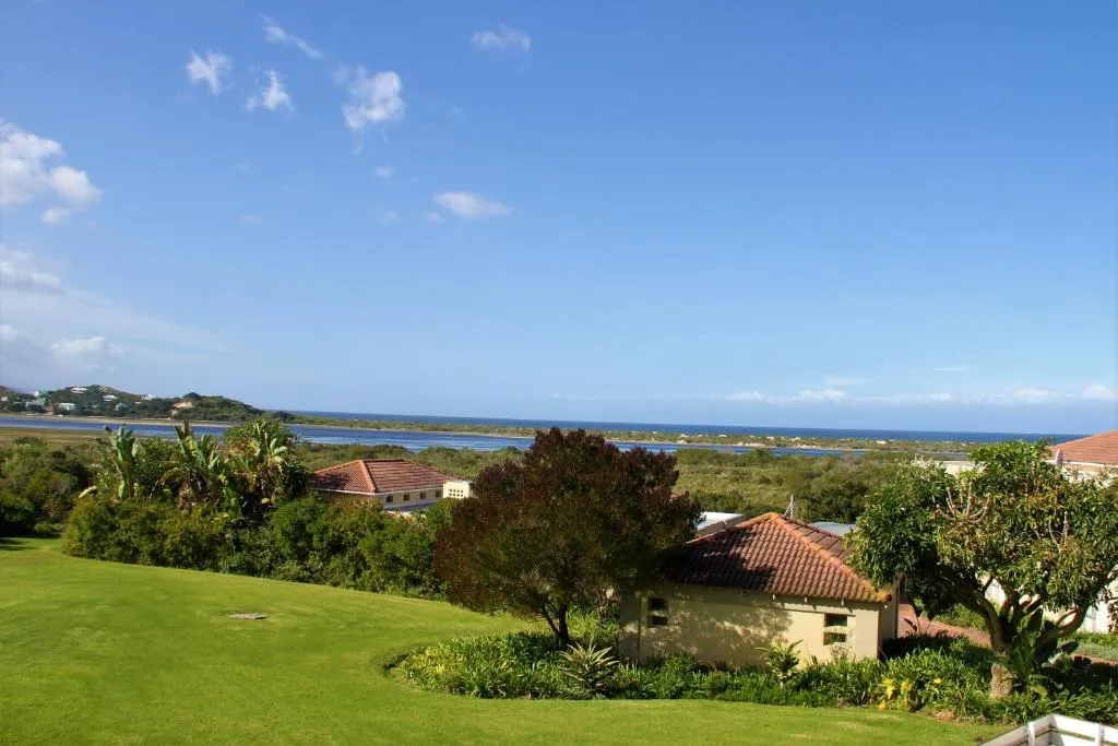 Estate lawn and garden sloping down toward the lagoon and coastline